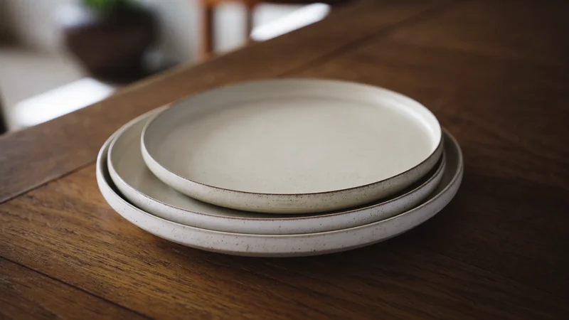 Pile de trois assiettes en grès tourné à l'émail mat tacheté